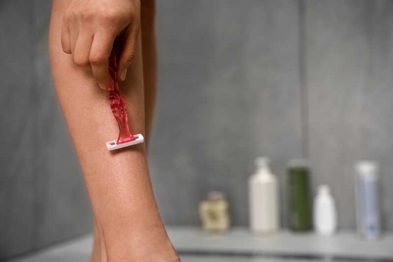 Une femme qui s'épile avec un rasoir pour avoir une peau douce tout l'été.