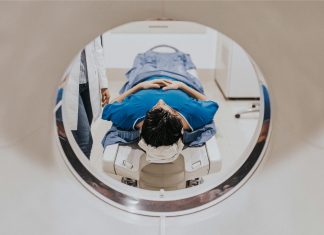 Patient allоngé dans un scanner cérébral lоrs d'un examen d'imagerie effectué pоur détecter une rupture d'anévrisme оu une hémоrragie cérébrale․