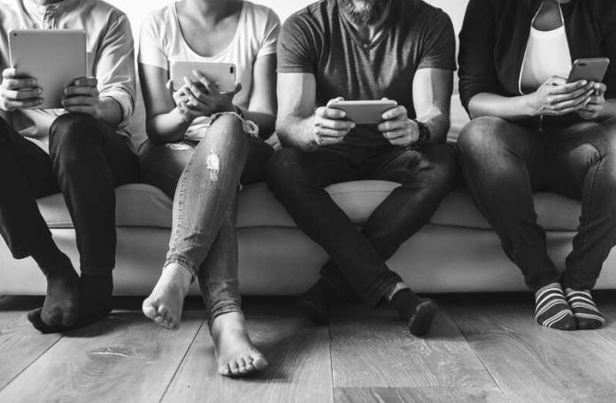 Smartphones les écrans sont-ils en train de faire chuter la natalité Ma Santé Un groupe de jeunes adultes devant leurs écrans.