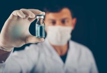 Un vaccin conçu par IA testé chez l’humain : une arme contre les futures pandémies ? Un chercheur tient dans ses mains un échantillon du nouveau vaccin conçu à l’aide de l’intelligence artificielle.