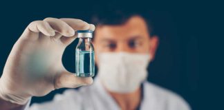 Un vaccin conçu par IA testé chez l’humain : une arme contre les futures pandémies ? Un chercheur tient dans ses mains un échantillon du nouveau vaccin conçu à l’aide de l’intelligence artificielle.