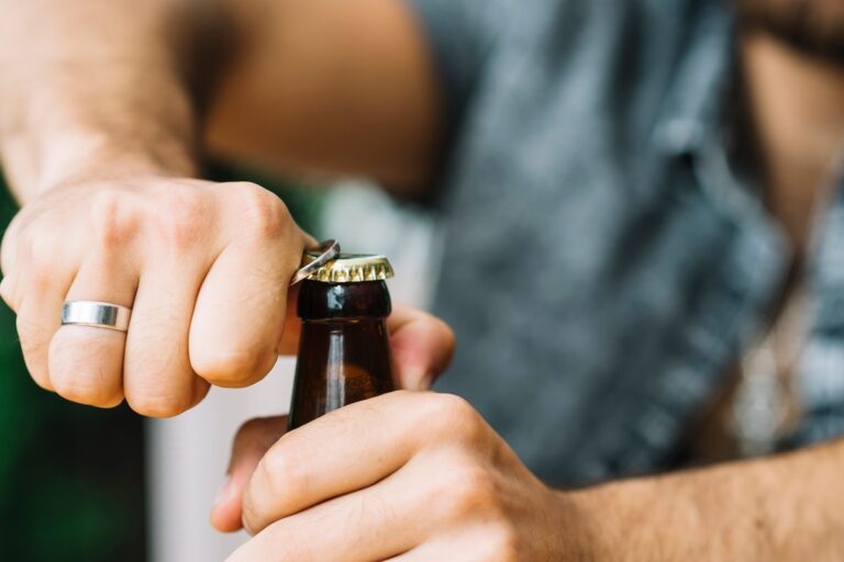 Un homme s'apprête à boire une bière, sans savoir que cette boisson pourrait attirer davantage les moustiques.