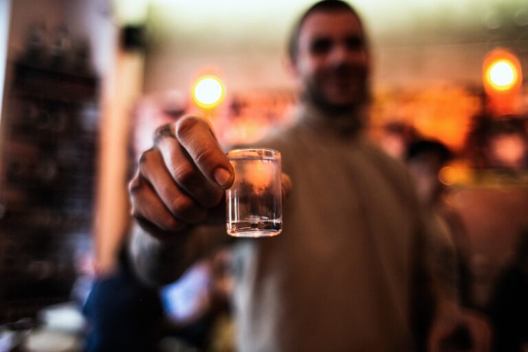Un homme dépendant à l'alcool qui se ressert continuellement à boire.