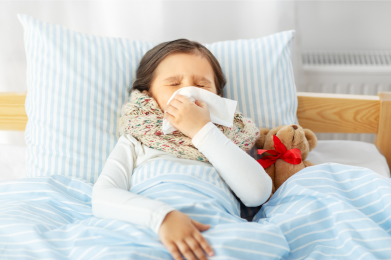Enfant enrhumé et malade se mouchant le nez dans son lit, suspectant les symptômes du bocarirus.