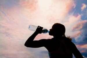 Une femme se prépare à la prochaine vague de canicule en s’hydratant.