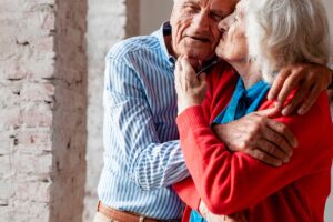 Un couple de centenaires qui se prend dans les bras.