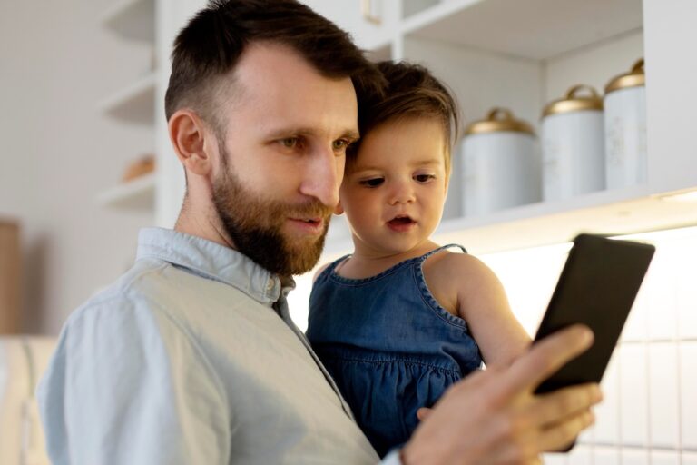 Un père scotché à son écran alors qu'il tient son enfant dans les bras.