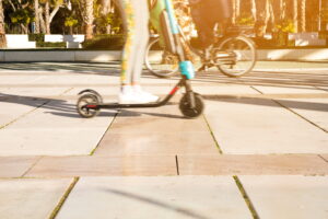 Une jeune femme filant à toute allure sur une trottinette électrique.