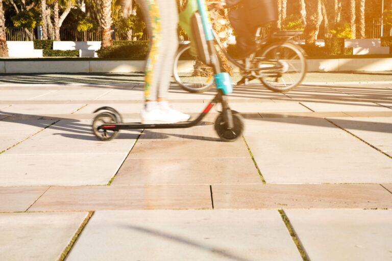 Une jeune femme filant à toute allure sur une trottinette électrique.