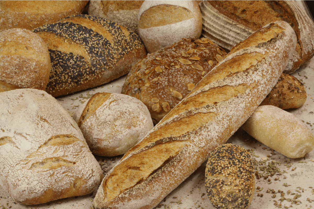 Assortiment de pains (baguette, pain complet et pains aux graines).