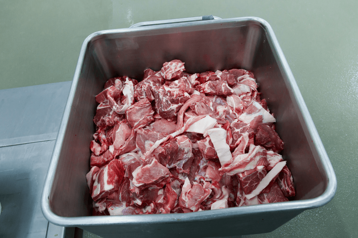 Morceaux de viande rouge dans un bac de boucherie.