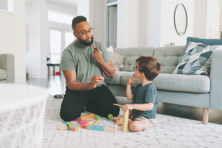 Parent communiquant par gestes avec un jeune enfant atteins du syndrome de Landau-kleffner lors d'un jeu.