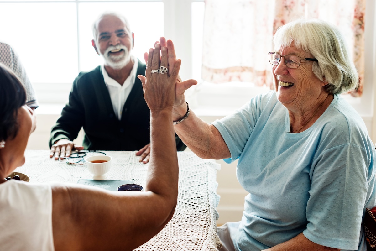 Un groupe de seniors en colocation jouant aux cartes.