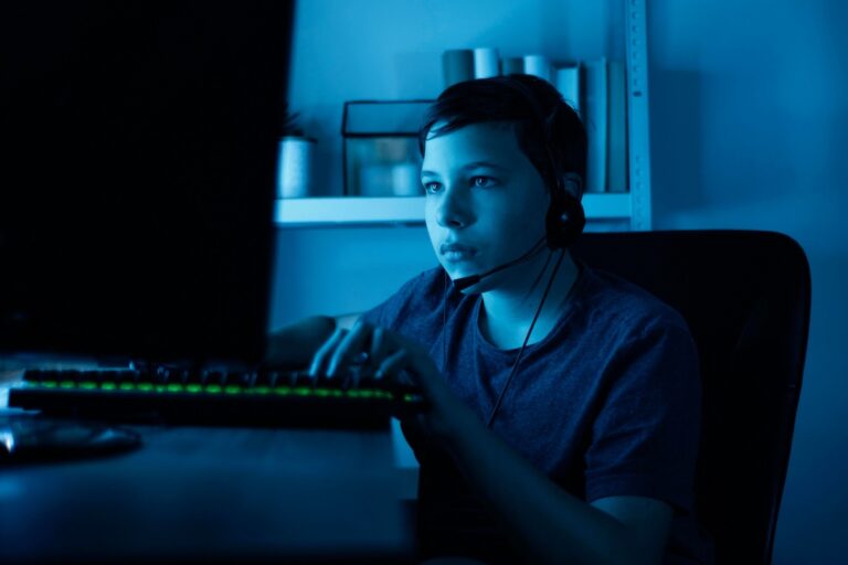 Un adolescent concentré devant son écran d’ordinateur.