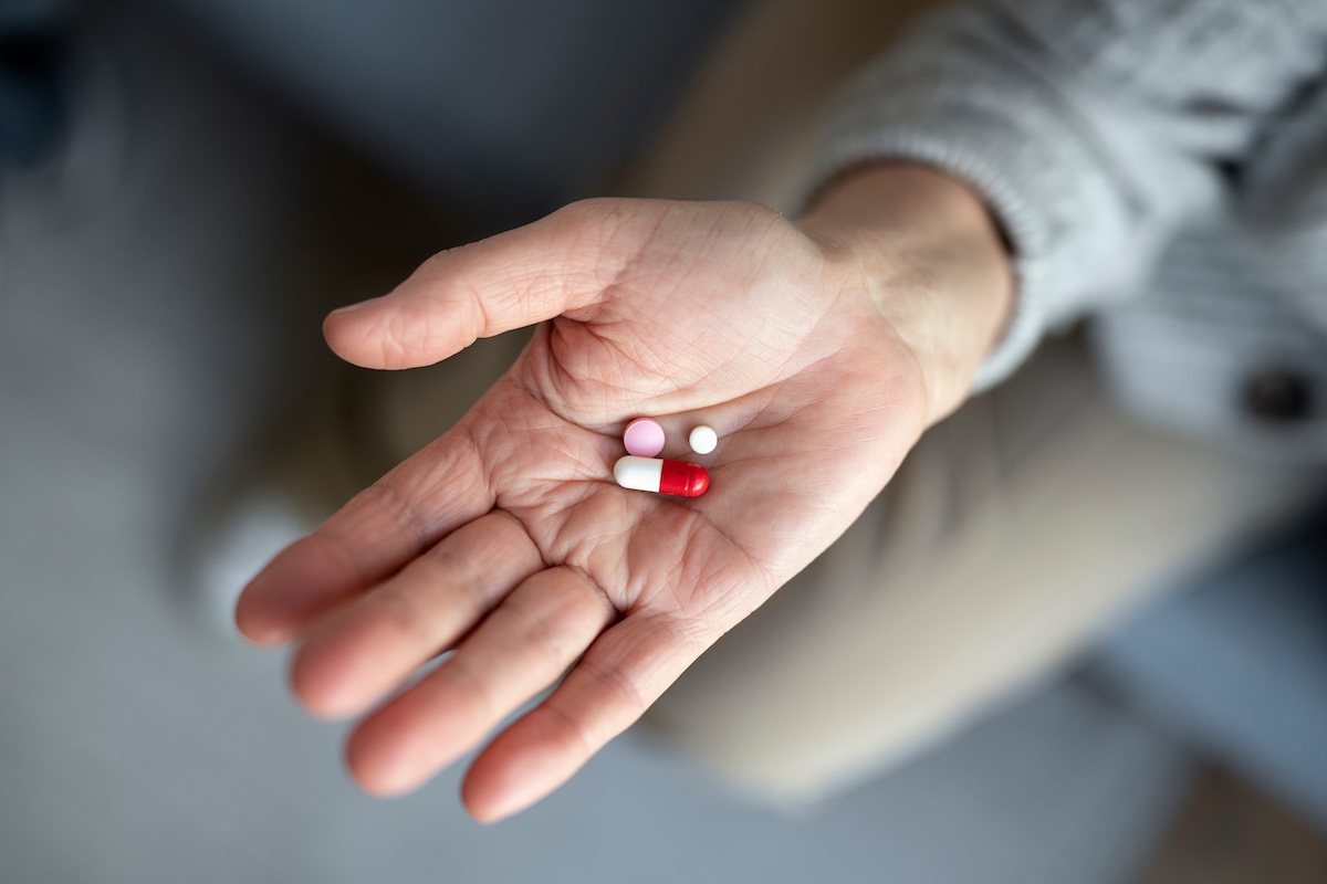Une femme tient dans sa main des médicaments dont la date de péremption pourrait être repoussée.