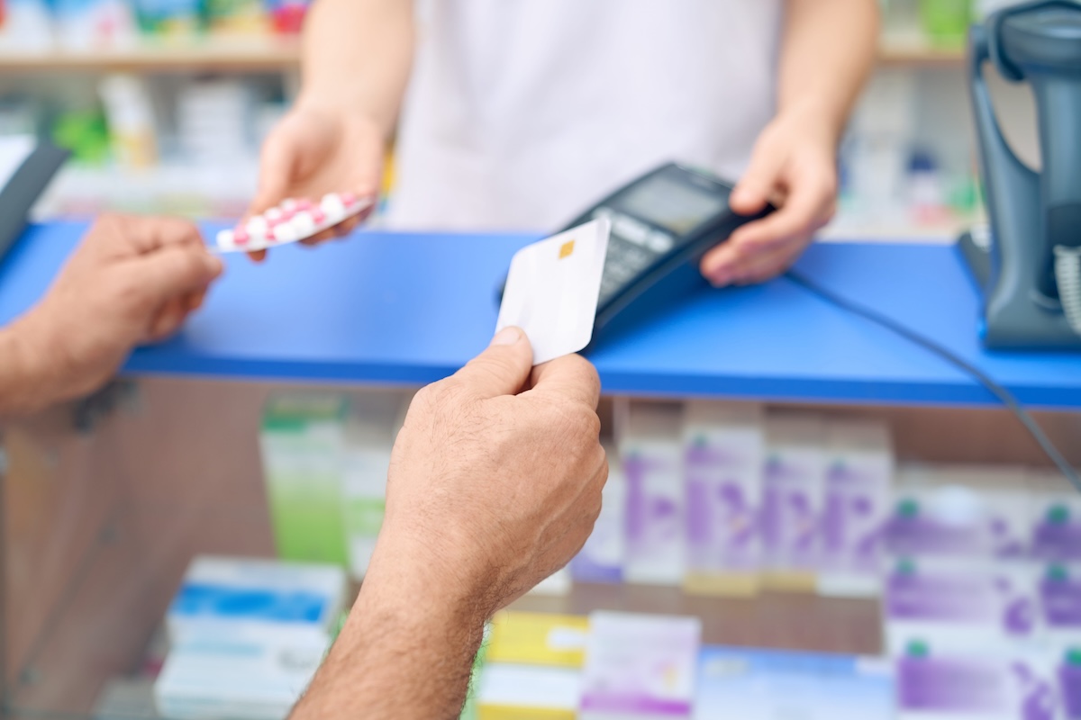 Un expatrié règle ses médicaments en pharmacie, des frais de santé qui peuvent être mieux couverts par une mutuelle complémentaire.