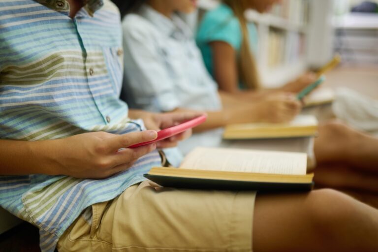 Des adolescents de moins de 15 ans sur leur téléphone, en train de consulter les réseaux sociaux.