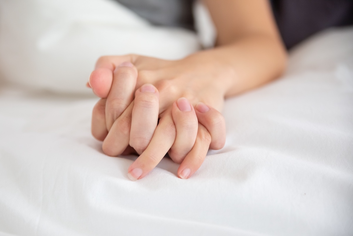 Les mains entrelacées d’un couple, symbole de complicité et d’une libido épanouie.