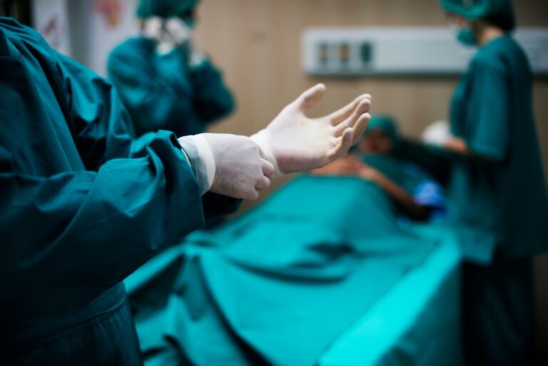 Un chirurgien enfile ses gants avant de procéder à une opération au bloc opératoire assistée par l'IA.