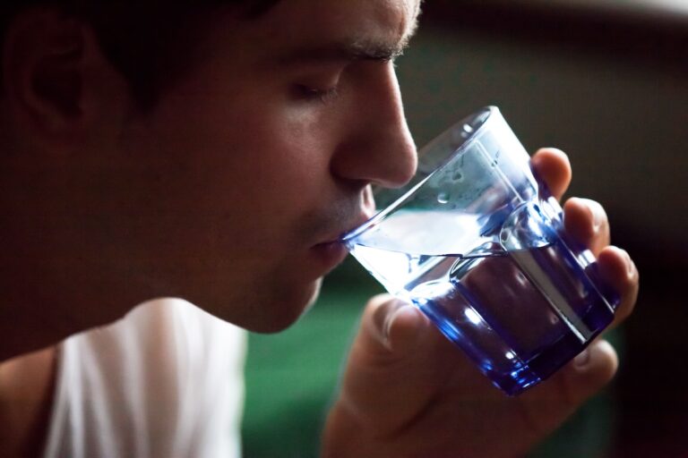 Un homme qui boit un soda sans savoir que sa consommation régulière pourrait être associée à un risque accru de cancer de l’estomac.
