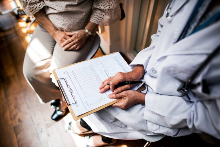Une patiente consulte un médecin, qui remplit son dossier médical et peut, si son état de santé le nécessite, lui prescrire un arrêt de travail.