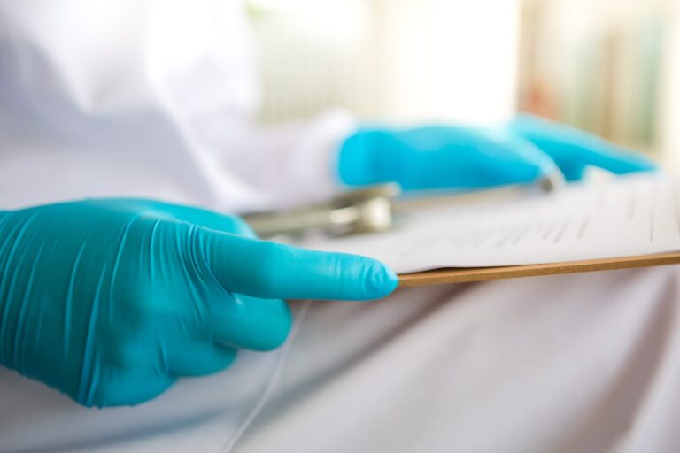 Un professionnel de santé consulte le dossier d’un patient afin d’évaluer sa prise en charge et son éventuelle participation à un essai clinique contre le cancer.