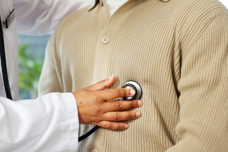 Médecin auscultant le cœur d’un patient avec un stéthoscope pour rechercher un trouble du rythme comme des extrasystoles.