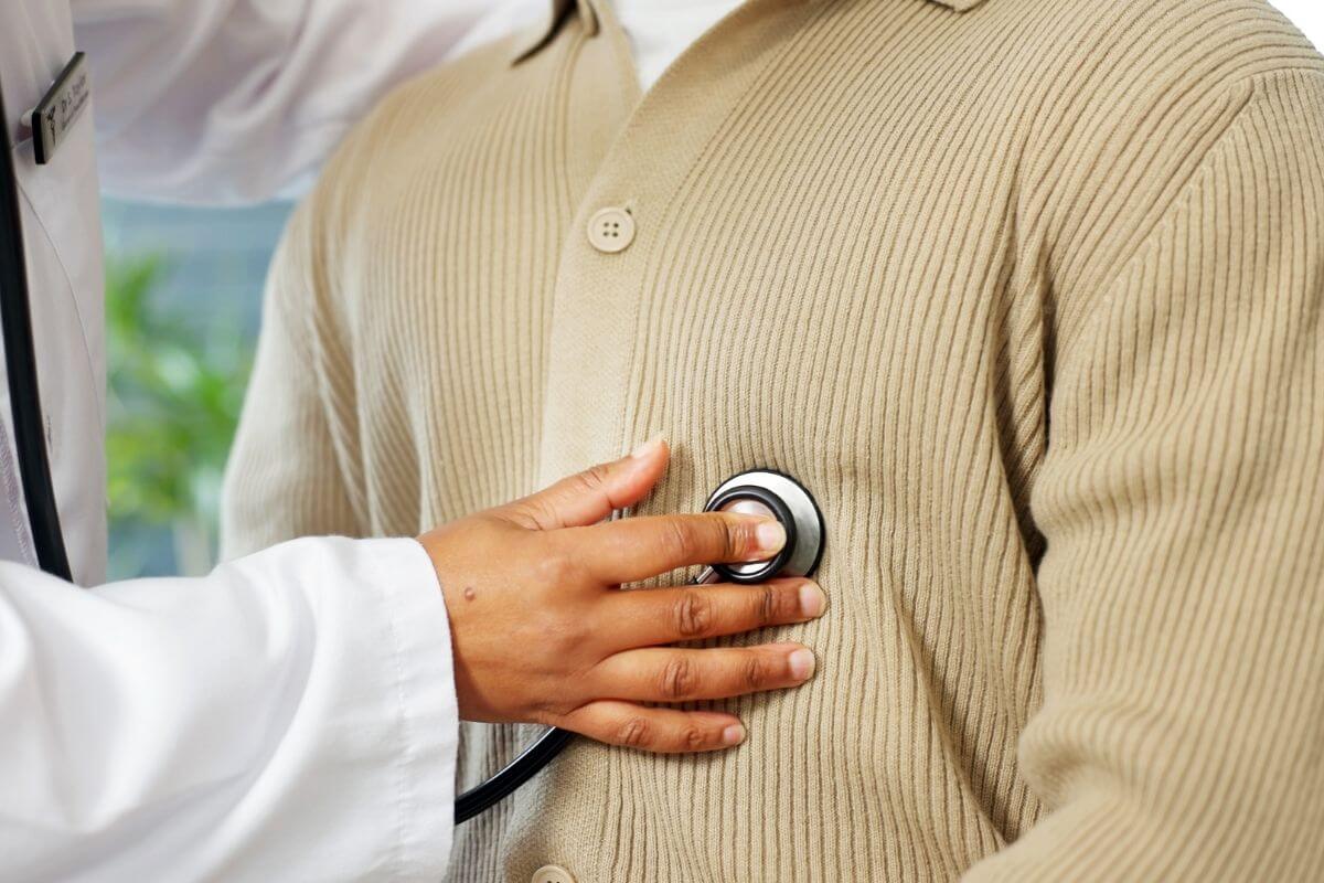 Médecin auscultant le cœur d’un patient avec un stéthoscope pour rechercher un trouble du rythme comme des extrasystoles.
