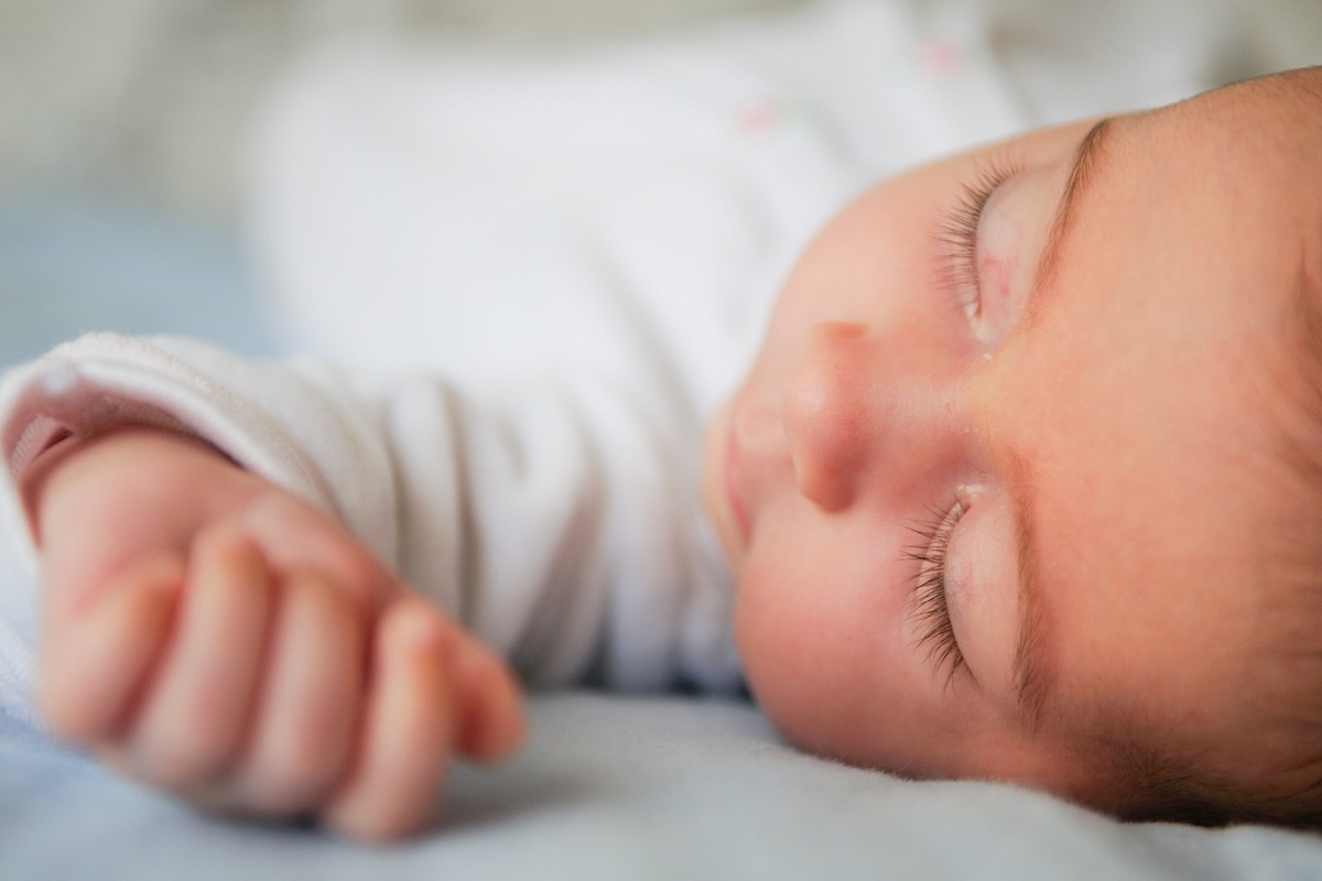 Un bébé dort sur le dos, la position recommandée pour réduire le risque de mort inattendue du nourrisson.
