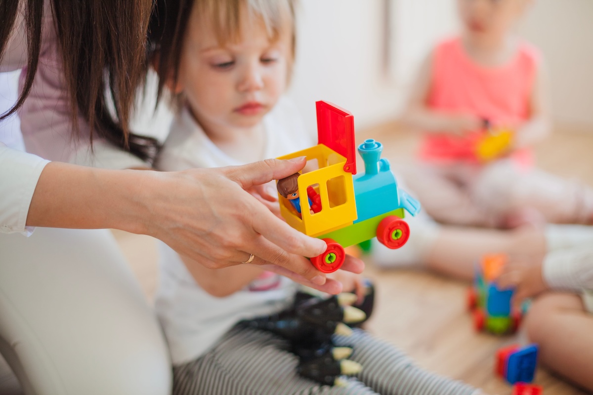 Une jeune enfant en train de jouer avec sa nounou.