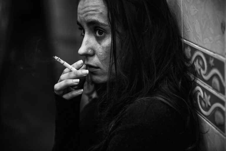 Une femme fume une cigarette, une habitude qui peut affecter sa fertilité et compliquer une grossesse.
