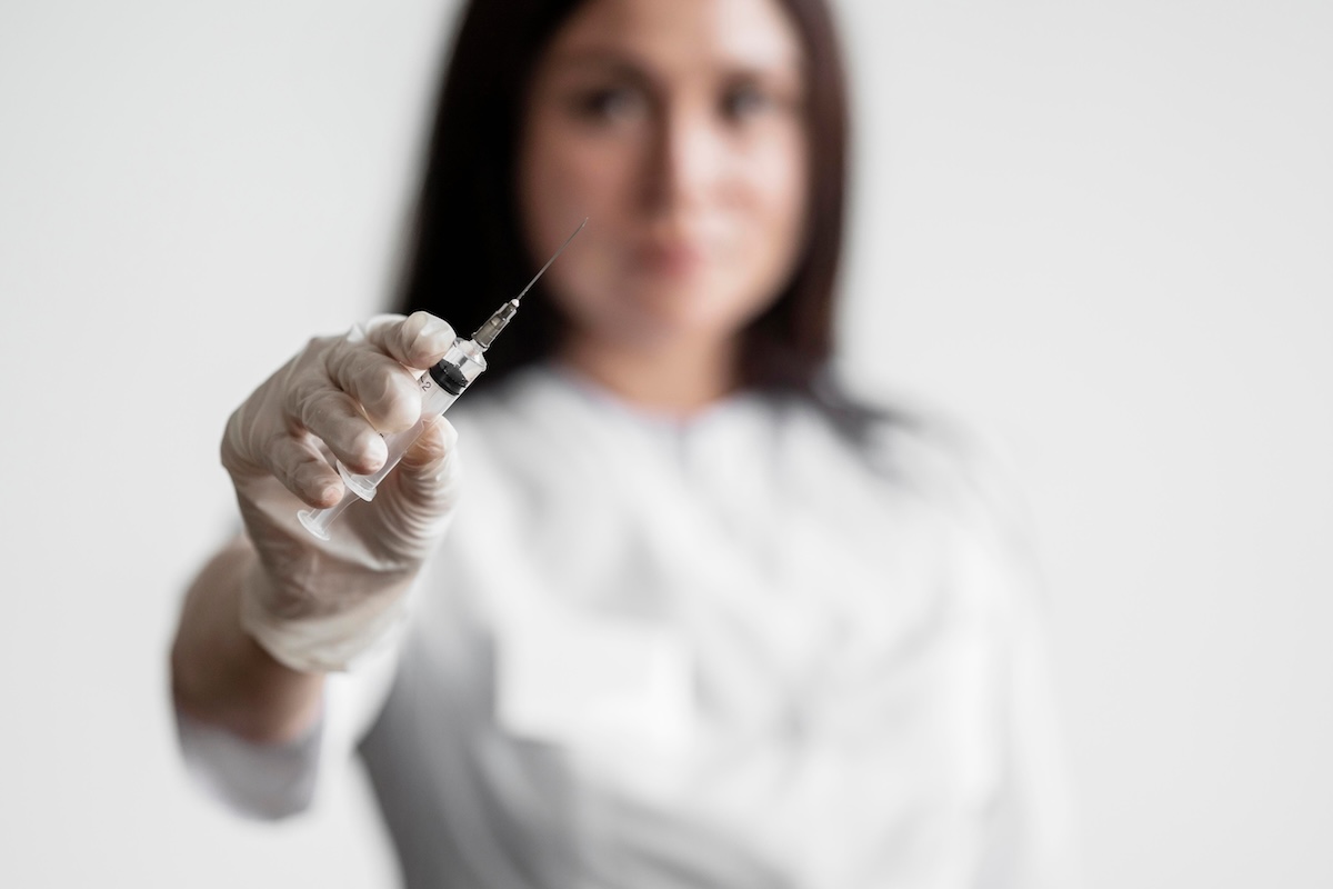 Un médecin qui prépare un vaccin pour prévenir les infections pouvant favoriser certains cancers.