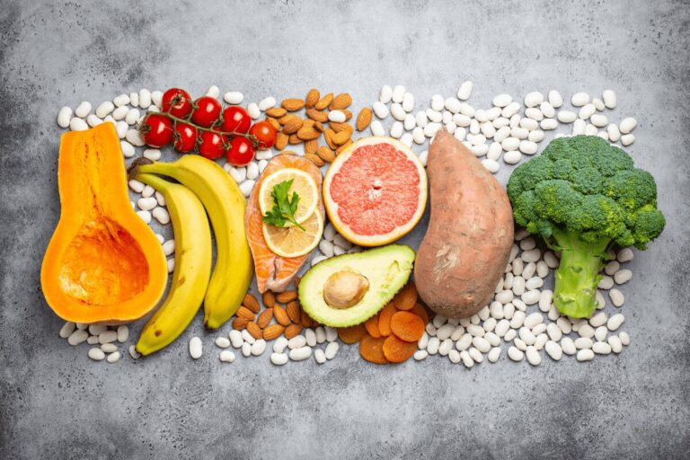 Assortiment d’aliments pouvant s’intégrer à une alimentation adaptée à l’hypertension, avec fruits, légumes, légumineuses, saumon, avocat et amandes.