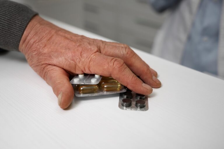 Une personne âgée qui prend plusieurs médicaments en même temps pour traiter différents problèmes de santé.