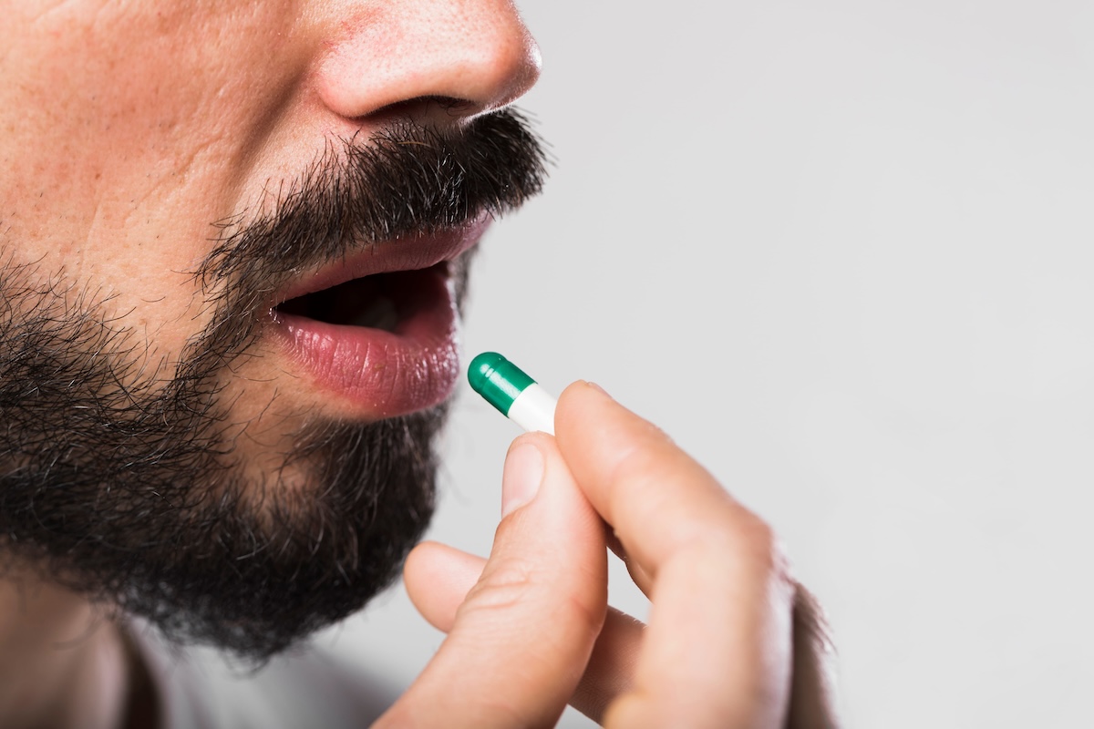 Un homme qui prend la dernière gélule de Prozac de sa plaquette.