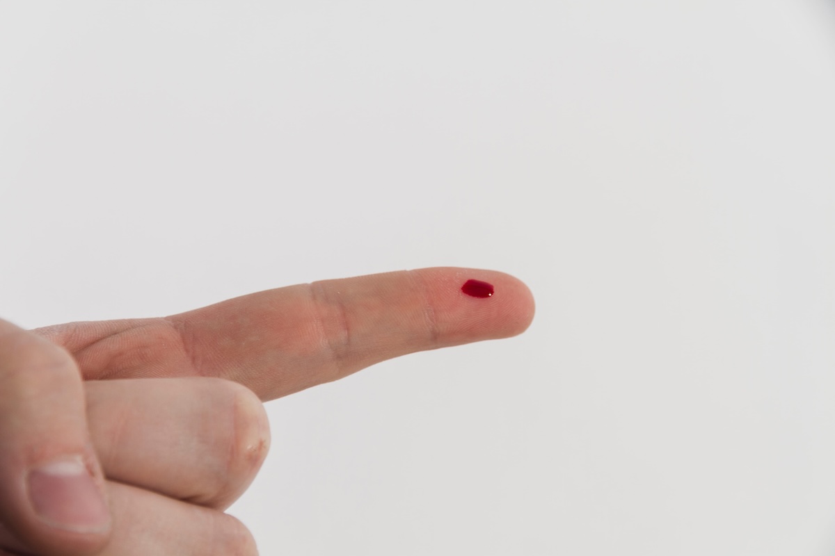 Une goutte de sang déposée au bout d’un doigt, qui sera utilisée pour aider à détecter un infarctus.