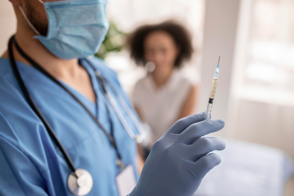 Un soignant se prépare à vacciner une personne à risque contre la grippe.