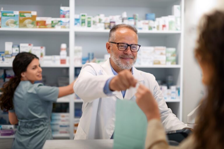 Un pharmacien tend à une jeune femme un sac contenant une culotte menstruelle remboursée.