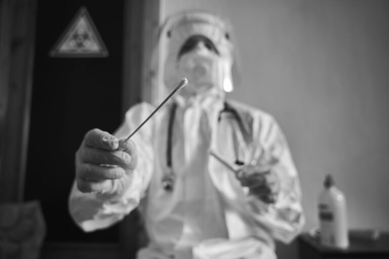 Un professionnel de santé en combinaison de protection réalise un prélèvement pour dépister une éventuelle infection par la peste.