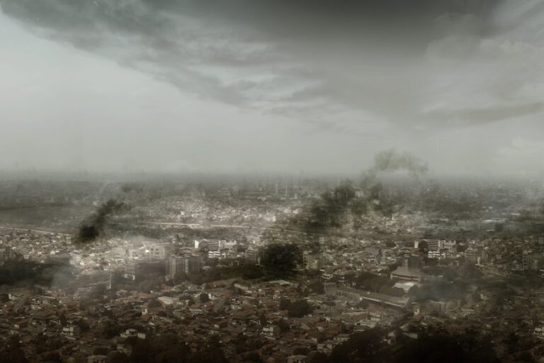 Une ville plongée sous un ciel menaçant, enveloppée d’un épais brouillard et de fumées sombres, illustrant ce à quoi pourrait ressembler le monde en cas de catastrophe majeure d’ici à 2100.