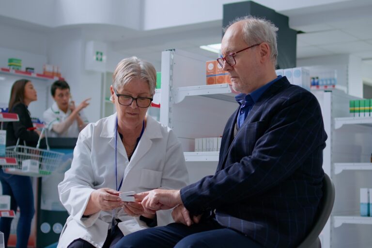 Une pharmacienne utilise un oxymètre de pouls placé au doigt d’un homme âgé pour mesurer son taux d’oxygène dans le sang et sa fréquence cardiaque.