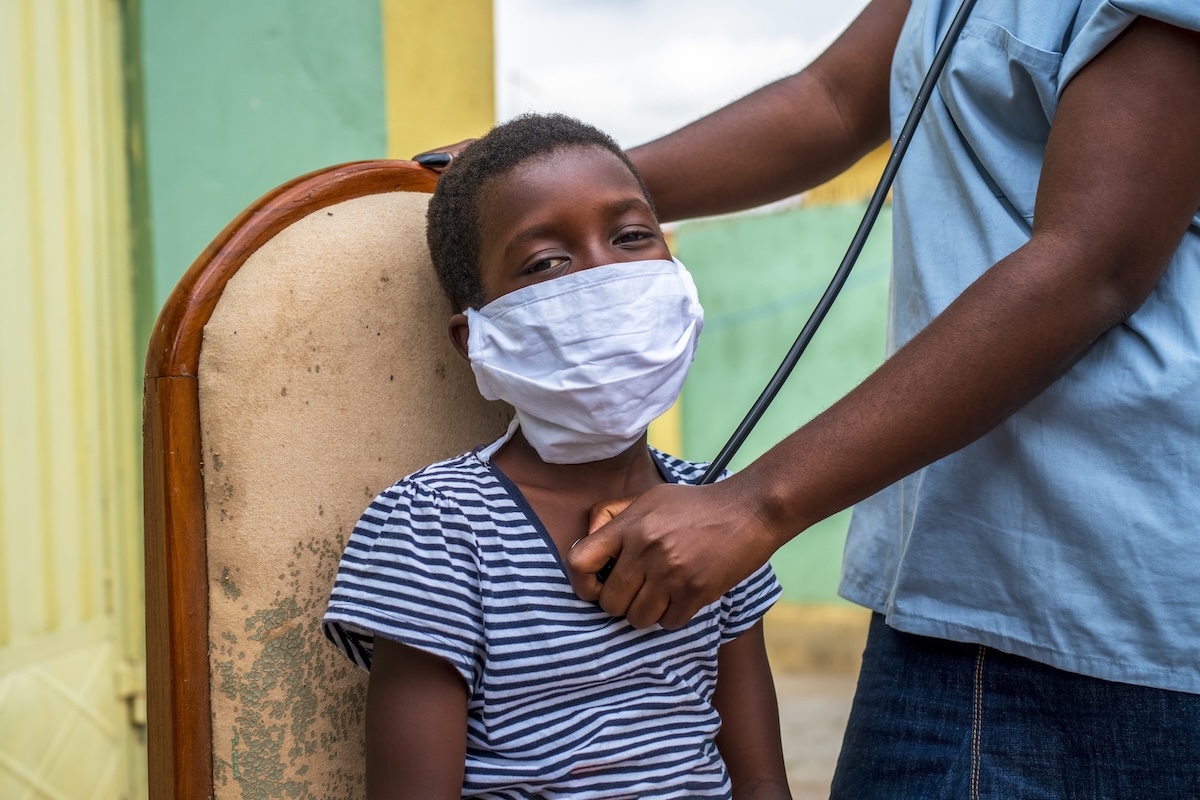 Un enfant atteint du virus Ebola en RDC se fait ausculter par un médecin.